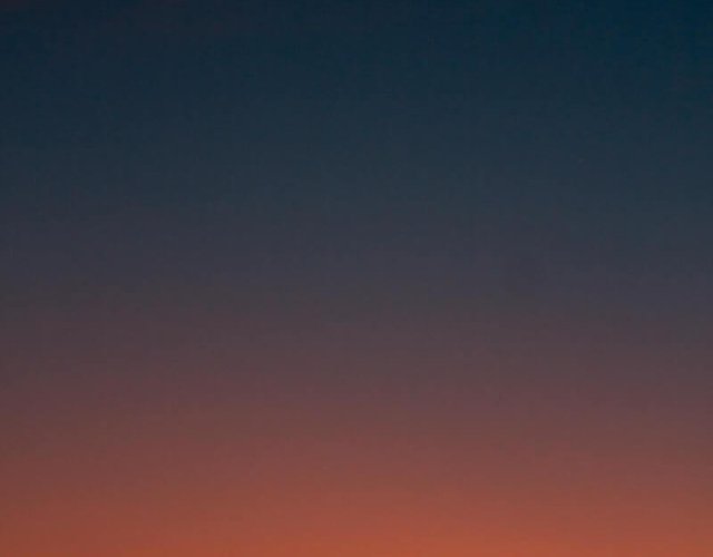 Fiery sunset with crescent moon Crescent moon and fiery orange sunset horizon