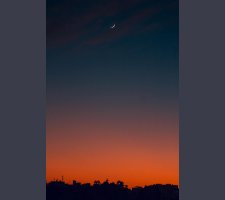 Fiery sunset with crescent moon Crescent moon and fiery orange sunset horizon