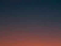 Fiery sunset with crescent moon Crescent moon and fiery orange sunset horizon